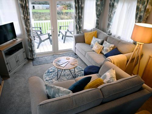 a living room with two couches and a table at Rose View in Newquay