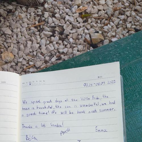 a page of a book with a handwritten letter on the rocks at Villa Frida in Sutomišćica