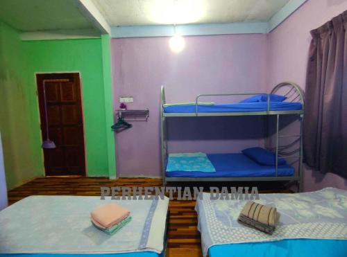 2 Etagenbetten in einem Zimmer mit Grün und Lila in der Unterkunft Perhentian Damia in Perhentian Island