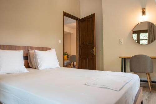 Μελίτη Pelion Luxury Living في زاغورا: غرفة نوم بسرير ابيض كبير ومرآة