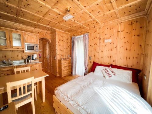 1 dormitorio con 1 cama en una cabaña de madera en Fewo Zirbenglück, en Bad Kleinkirchheim