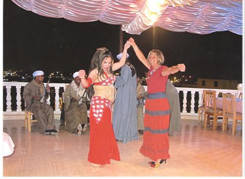 two women standing on a dance floor with their hands in the air at El Mesala Hotel in Luxor