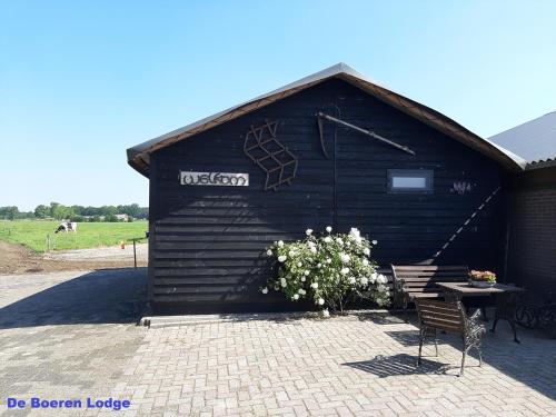 a building with a bench and a table in front of it at Hofstay195 in Achterveld