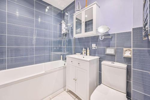 a bathroom with a toilet and a sink and a tub at Muntham Luxury Holiday Apartments in Torquay