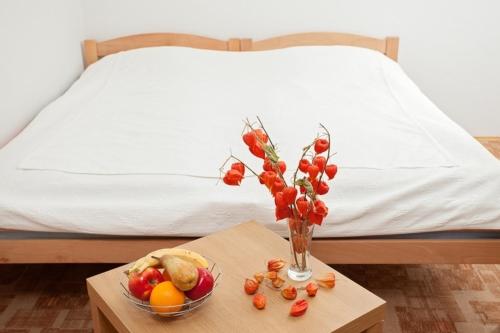 a vase of fruit on a table next to a bed at Apartments Castanea in Sarajevo