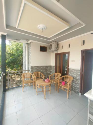 a patio with chairs and tables on a balcony at Cahaya Homestay in Magelang