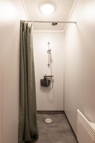 a shower in a bathroom with a shower curtain at Høgtun kulturklynge in Olsborg