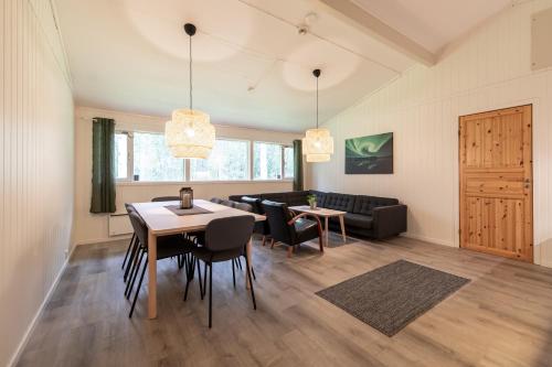 sala de estar con mesa, sillas y sofá en Høgtun kulturklynge en Olsborg