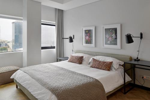 Lovely 2 bedroom rental unit close to the V&A Waterfront في كيب تاون: غرفة نوم بيضاء بها سرير ونافذة