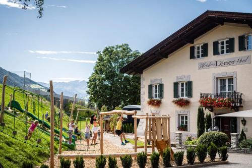 a group of children playing on a playground in front of a building at Hotel Lener in Vipiteno
