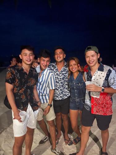 a group of people posing for a picture on the beach at Fable Hostel in Siquijor