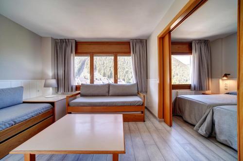 a hotel room with two beds and a couch at Apartamentos Solneu in Baqueira-Beret