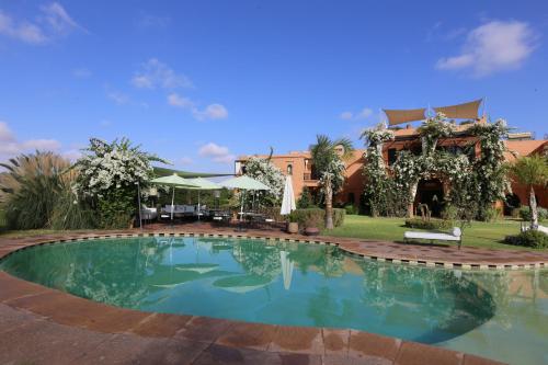 a swimming pool in front of a house at Riad Al Mendili Private Resort & Spa in Had Abdallah Rhiat