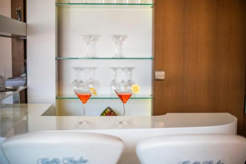 two wine glasses sitting on a table with drinks at Theatre Lodge Attico teatro in Merano