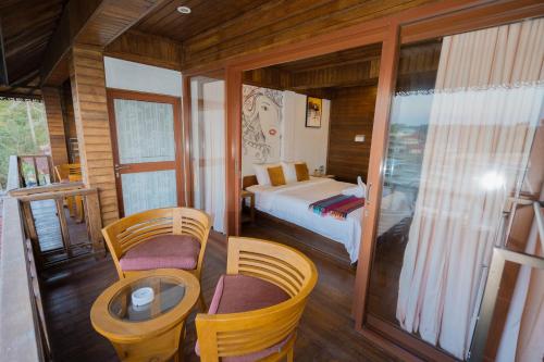 een slaapkamer met een bed en een tafel en stoelen bij Dava Villa Ocean View in Nusa Penida