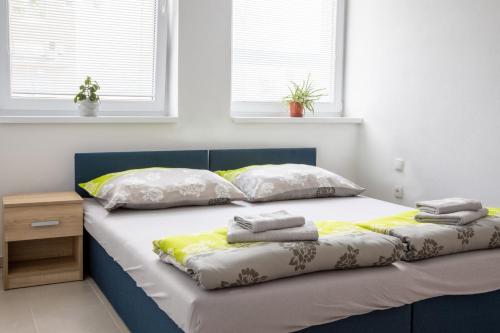 a bed in a bedroom with two pillows on it at Motorest Farmárik in Topoľčany