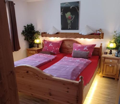 ラムにあるAm Postgartenのベッドルーム1室(ピンクの枕が付いた大きな木製ベッド1台付)