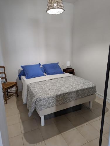 um quarto com uma cama com almofadas azuis em le cocooning marseillais bis em Marselha
