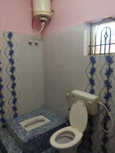 baño con aseo y ventana en Hidden gem home stay -2, en Madikeri