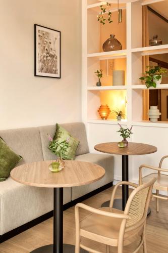a living room with two tables and a couch at Meliá Düsseldorf in Düsseldorf