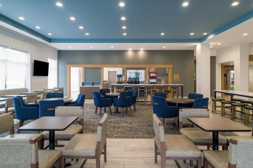 a restaurant with tables and chairs and a bar at Staybridge Suites - Louisville - Expo Center by IHG in Louisville