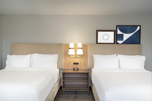 two beds in a hotel room with white pillows at Staybridge Suites - Louisville - Expo Center by IHG in Louisville