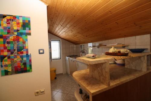 uma cozinha com um tecto de madeira e uma bancada em Apartments with a parking space Nin, Zadar - 11402 em Nin