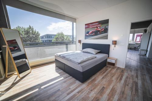 a bedroom with a bed and a large window at Pit Stop Apartments in Cham