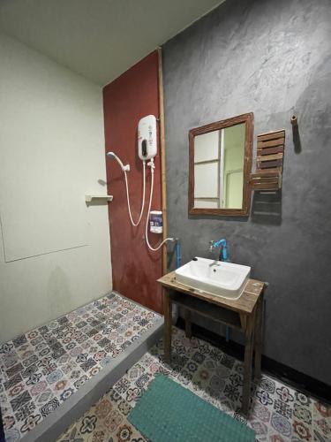 een badkamer met een wastafel en een spiegel bij Pano Solar Guest House (พาโน โซล่า เกสเฮ้าส์ ) in Trat