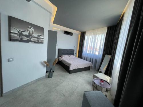1 dormitorio con 1 cama y 1 silla en una habitación en Engels apartments - studio luminos en Cluj-Napoca