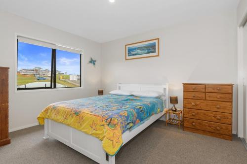 1 dormitorio con 1 cama, vestidor y ventana en Beach Haven - Karikari Peninsula Holiday Home en Karikari Peninsula