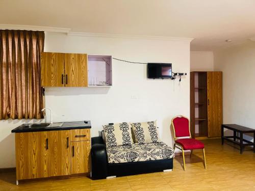 sala de estar con sofá y silla roja en Goza Guest House, en Addis Ababa