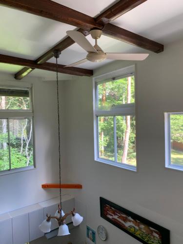 a ceiling fan in a kitchen with three windows at Sai's House Hakuba in Hakuba