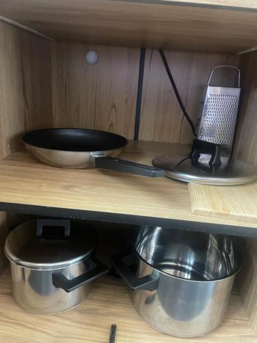 a shelf with two bowls and a pan on it at Bison Apartamenty in Białystok
