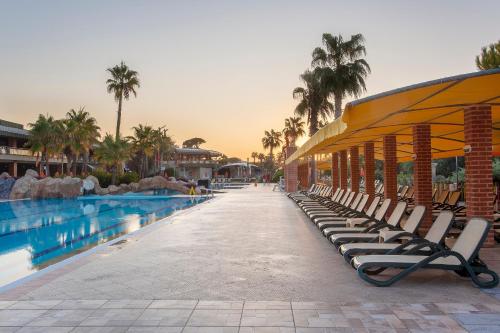 eine Reihe von Liegestühlen neben einem Pool in der Unterkunft MEDWORLD Health & Rehabilitation Center Pine Beach Belek in Belek