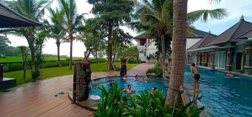 a group of people in a swimming pool in a house at Kori Maharani Villas - Lagoon Pool Access 4 in Siyut