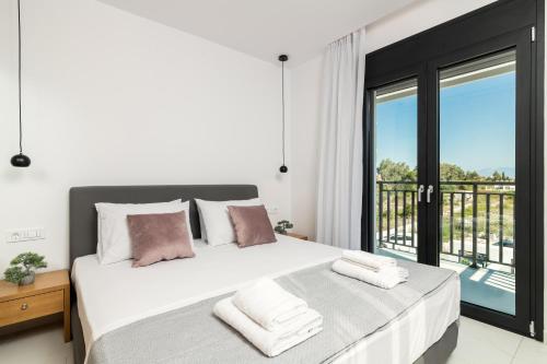 Schlafzimmer mit einem großen Bett und einem Balkon in der Unterkunft Eagle's Nest - Adjoining Villas! in Planos