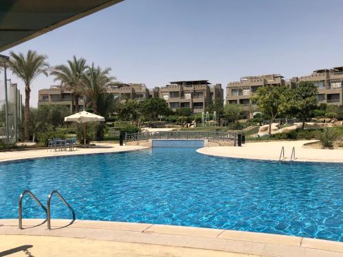 una piscina in un resort con edifici sullo sfondo di einbay 3 bedrooms garden + pool view a Ain Sokhna