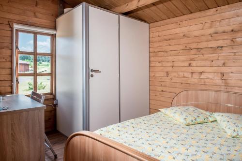 1 dormitorio con cama, escritorio y ventana en Nameliai ant ežero kranto, en Kaišiadorys