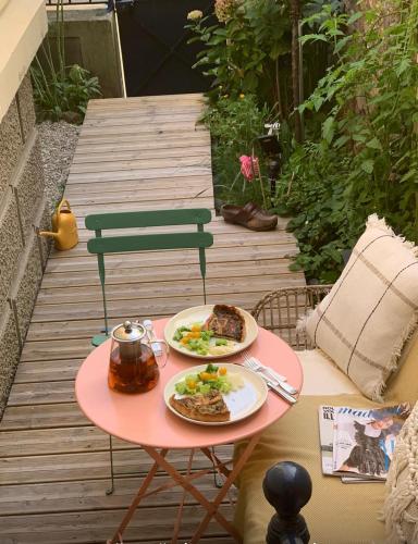 - une table avec deux assiettes de nourriture sur la terrasse dans l'établissement Persévérance, à Dinard