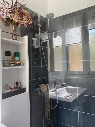 une salle de bain avec un lavabo et un miroir dans l'établissement Persévérance, à Dinard