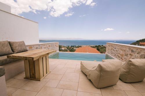 a patio with a wooden table and chairs and a pool at Mani Luxury Suites and Studios in Gytheio with Private Pools in Gythio