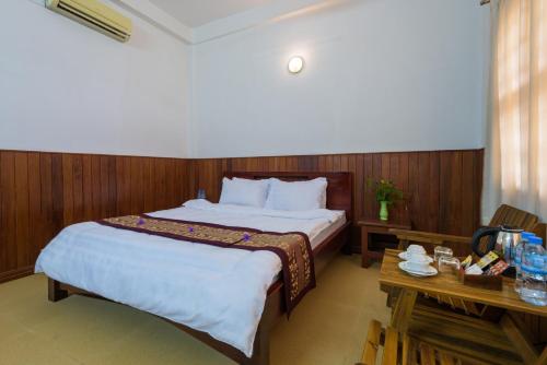 a hotel room with a bed and a table at Heng Long Villa in Siem Reap