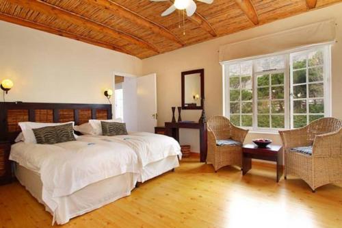 a bedroom with a bed and a table and chairs at Cape Paradise Lodge and Apartments in Cape Town