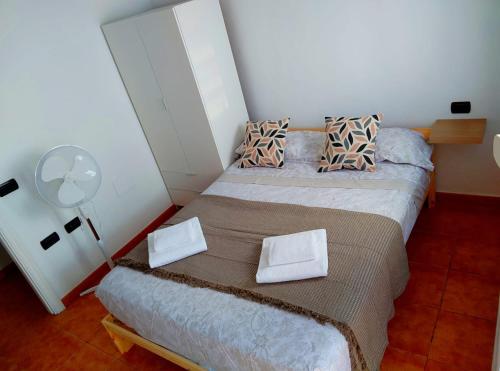 a small bedroom with two beds and a fan at Sea view apartment in Alcalá in Alcalá