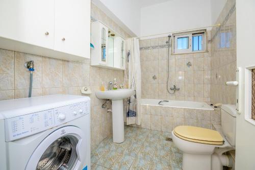 a bathroom with a washing machine and a sink at Sea view relaxing home in Mesimvría