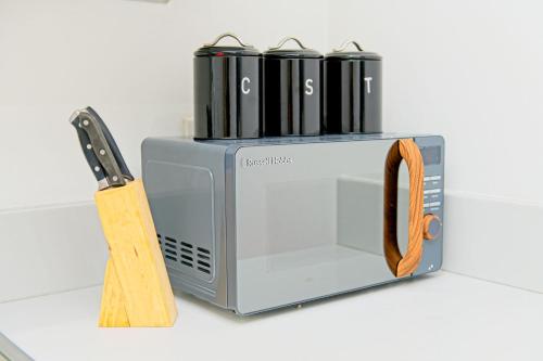 a toaster oven on a counter next to a knife at 2 Bedroom Chinatown Apartment in Birmingham