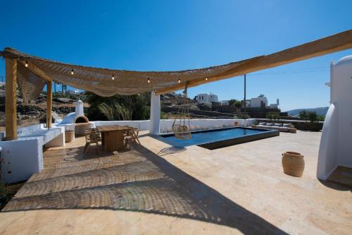 a patio with a hammock and a swimming pool at Little Villa amid Super Paradise-JackieO' Mykonos in Super Paradise Beach