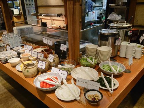 a table topped with lots of different types of food at Nishitetsu Inn Shinjuku in Tokyo