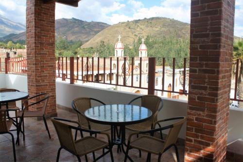 a balcony with tables and chairs and a view of a mountain at Huascarán Inn in Mancos